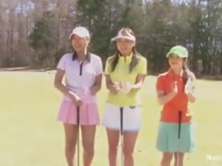 Bedårande asiatiskapojke tonårs flickor spela en spel av remsan golf