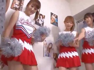 Kolme iso tiainen japanilainen cheerleaderit jakaminen miehuus